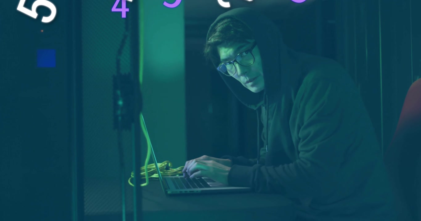 Hooded coder coding on laptop amid tech cables as purple numerals swirling fading revealing profile