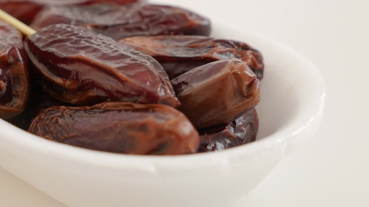 Exotic fruit palm dates on white surface 4K