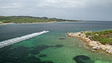 Vista-Aérea-Panorámica-Del-Lago-De-Levico-Con-Exuberantes-Colinas-Verdes-Y-Tranquilas-Aguas-Reflectantes-Bajo-Un-Cielo-Nublado