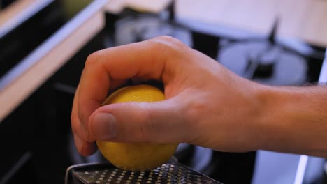 the cook rubs a lemon on a grater