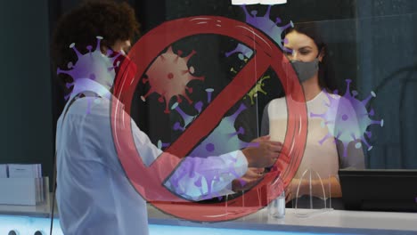 animation of virus icons with prohibition sign over biracial male receptionist with face mask