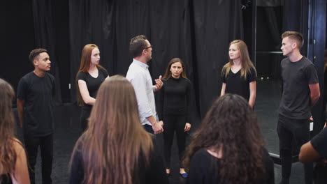 teacher with drama students at performing arts school in studio improvisation class