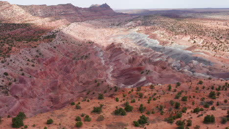 Drone-drops-down-and-flies-through-colorful-rock-formation-near-Tuba-City,-AZ