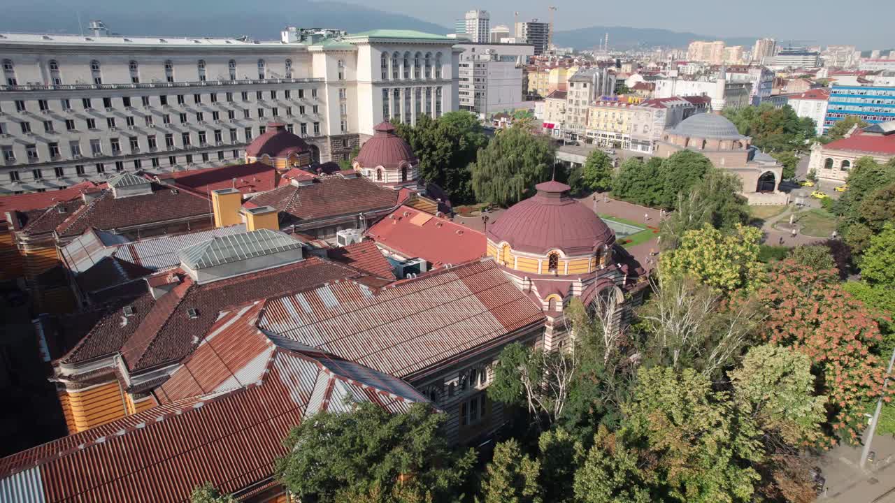 elevación aérea junto a los árboles para revelar las vistas del paisaje urbano de sofia en bulgaria, la mezquita banya bashi y el museo de historia regional