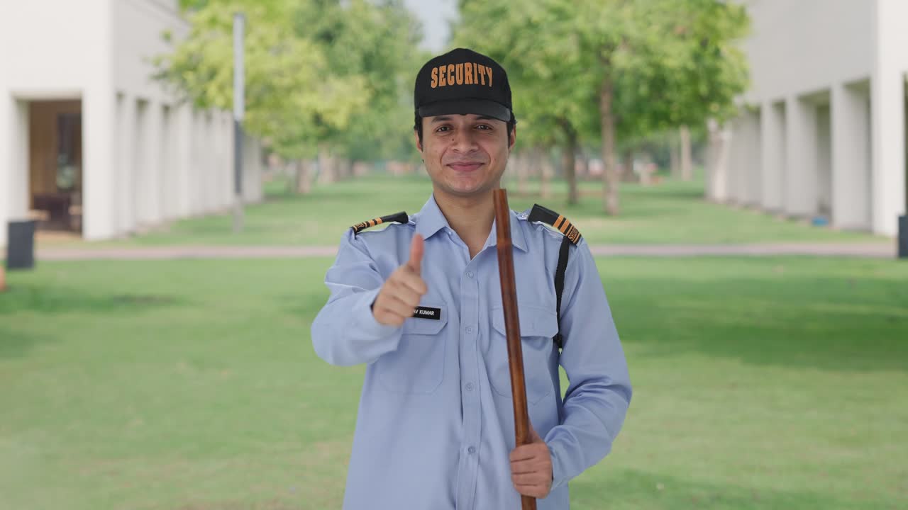 un guardia de seguridad indio feliz mostrando los pulgares hacia arriba