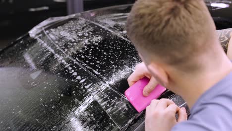 man covering car with vinyl polyurethane tape. films for the car. sticker protective film on the car