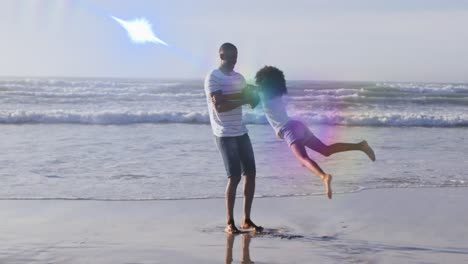 Animation-of-light-spots-over-african-american-father-with-daughter-at-beach