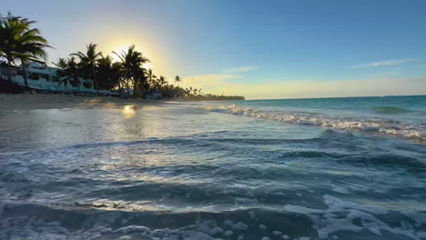 olas rodando en una playa de arena en punta cana, dominicana al atardecer