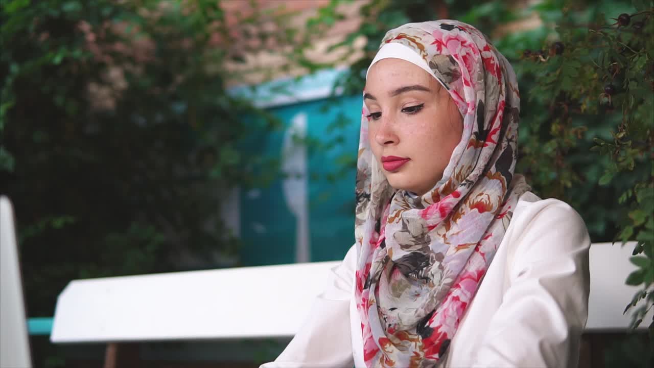 야외 카페에서 노트북으로 일하는 젊은 여성