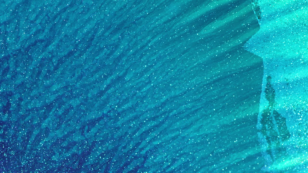 Levendige inktmenging in macro, waarbij abstracte blauwe oceaanpatronen ontstaan