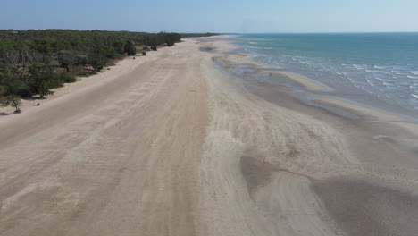 Disparo-Lento-De-Un-Dron-Alejándose-De-La-Playa-Hacia-El-Agua-En-El-Punto-De-Sotavento-En-El-Territorio-Del-Norte