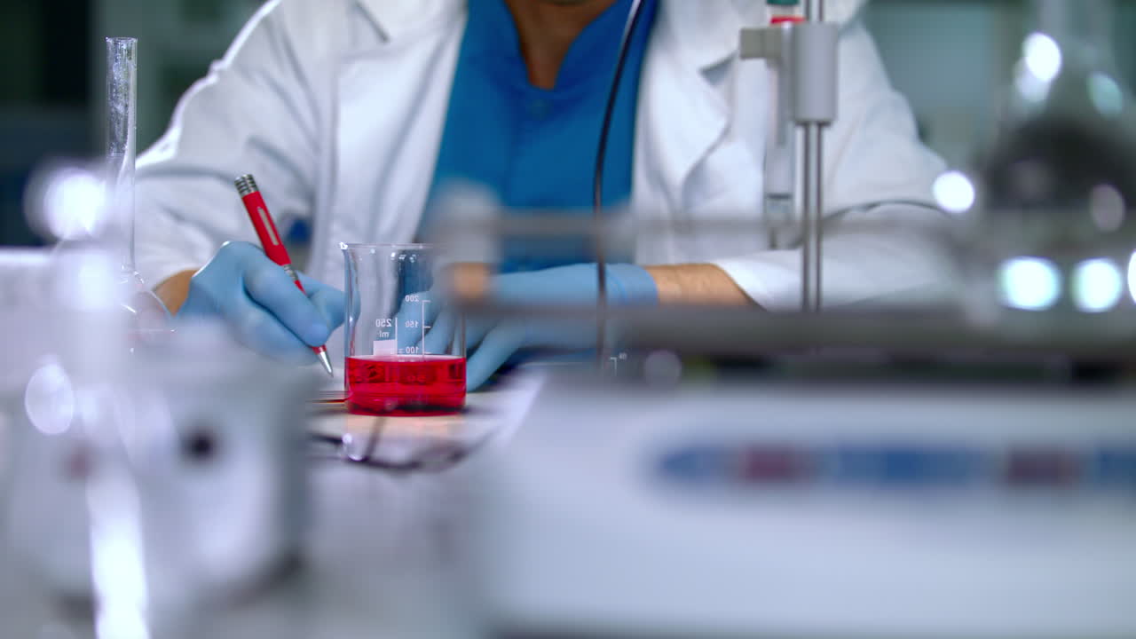 investigador escribiendo datos de investigación con pluma en el laboratorio. primer plano de las manos del científico