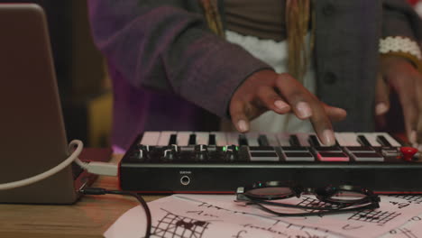 chanteuse avec synthétiseur et microphone répétant en studio d'enregistrement