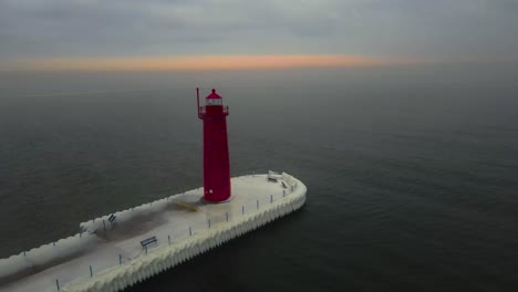 una puesta de sol sobre el lago michigan después de una tormenta de hielo