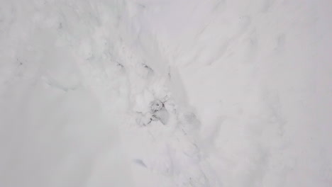 Luftaufnahme-Von-Oben-Nach-Unten,-Winteraktivitäten-Kind-Rodelt-Den-Weißen,-Schneebedeckten-Hügel-Hinunter