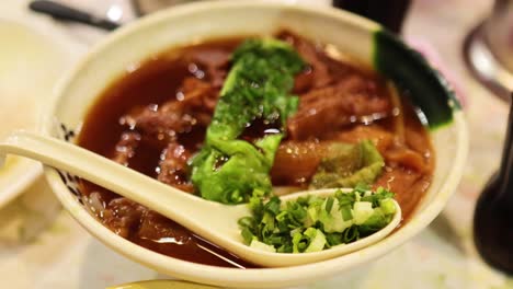 delicious beef noodle soup with fresh greens