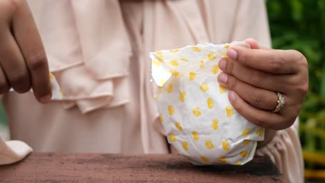 woman opening food package outdoors