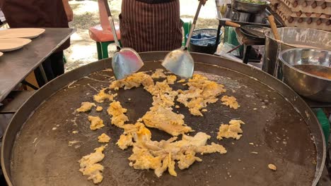 stir-frying pad thai noodles in an outdoor setting