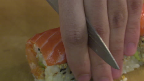 cortar los rollos de sushi de salmón
