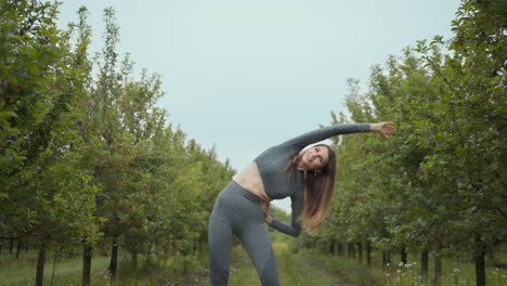 mujer estirándose al aire libre en un huerto