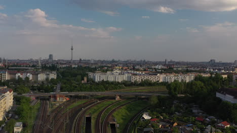 Aufsteigende-Aufnahmen-Von-Stadtlandschaften-Mit-Fernsehturm-Als-Dominante.-Fliegen-über-Schienenverkehrsinfrastruktur.-Berlin,-Deutschland