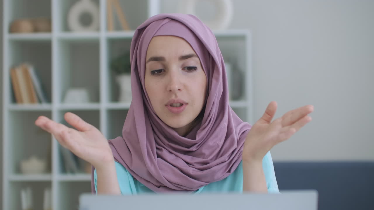 Wanita bisnis muda India berhijab berkomunikasi dengan pekerja jarak jauh dalam obrolan konferensi webcam. Guru daring Muslim melakukan wawancara kerja panggilan video