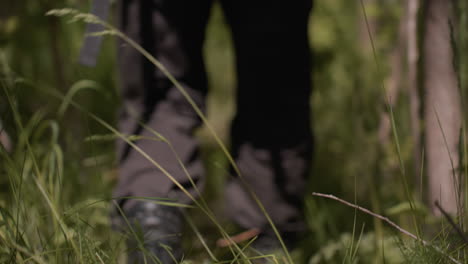 close up view of soldier jungle boot shifting and waggling through tall grass under canopy shadows capturing textured tread movement and earthy ambience of stealthy forest traverse