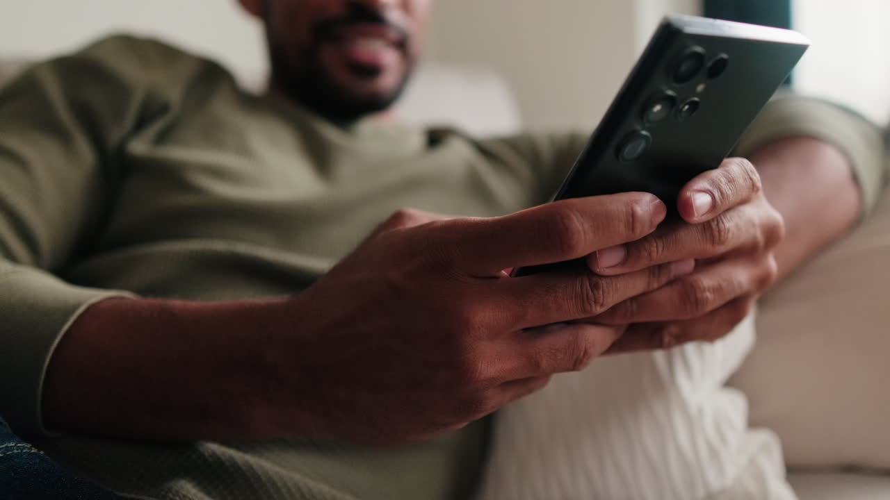 Man Relaxing at Home Using Smartphone
