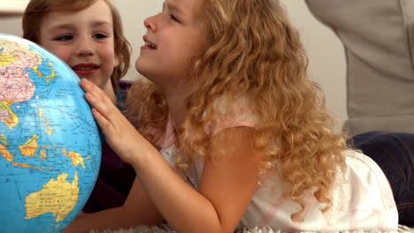 cute siblings looking at globe