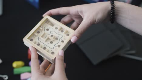 close up of a wooden box with a small ball going in holes