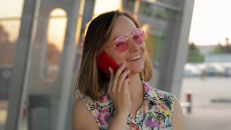 girl wearing trendy sunglasses uses her phone. using smartphone for call, talk. vacations, tourism