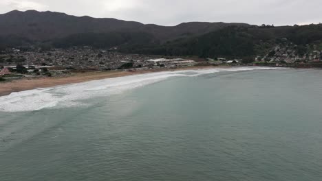 slow-dramatic-drone-shot-panning-to-the-left-of-surfers-in-the-ocean