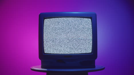 vintage tv with static on a white table
