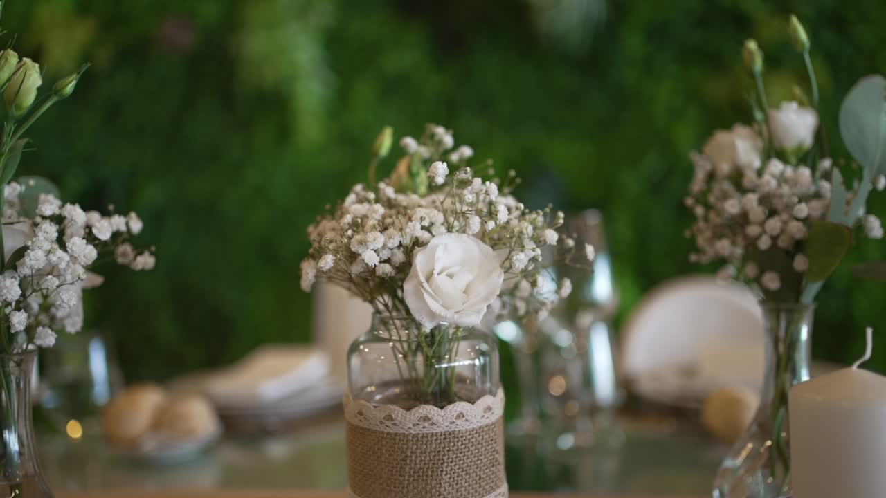 Glass jar with white flowers and lace decoration on dining table