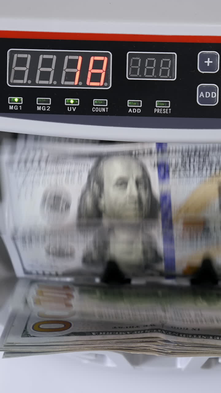 Money counting machine with 100 dollar banknotes. US national paper currency. Bank automatic equipment for calculation paper currency, finance concept Vertical video