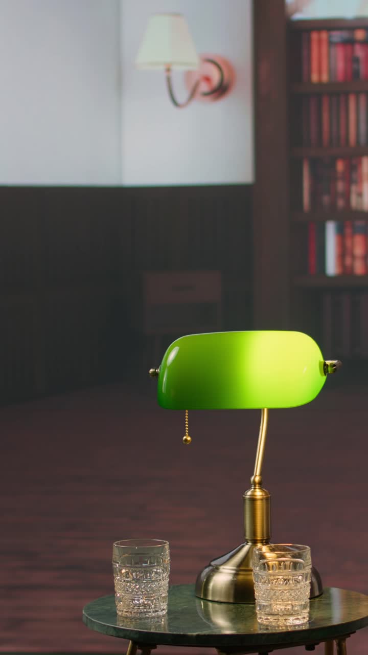 Green Banker's Lamp and Glasses on Table in Library Setting