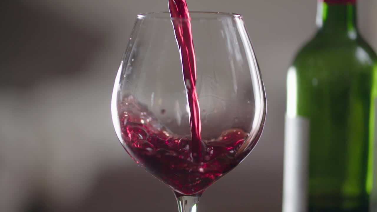 un vaso de vino tinto que se vierte en cámara lenta extrema