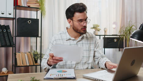 freelancer man accountant works with financial graph documents calculate taxes for charts at office