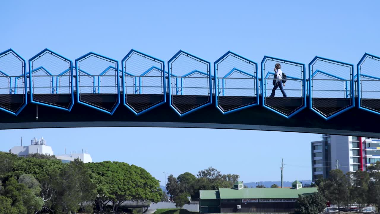 개인이 기하학적 파란 다리를 건너고 있습니다.