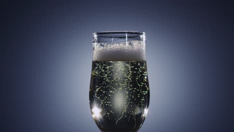 bubbles of champagne wine disappear from the beverage slow motion bubbles of champagne wine disappear from the beverage sparkling in tall glass alcohol drink is poured to brim and raised foam shines in light side view blue background slow motion