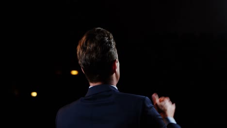 Rear-view-of-male-business-executive-giving-a-speech