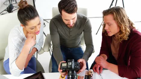 fotógrafos que miran fotografías en una cámara digital