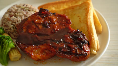 barbecue pork steak with rice berry on white plate