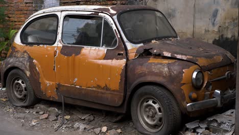 Coche-Viejo,-Fiat-500,-Bangkok,-Tailandia-Quemado-Abandonado-Tirado-Al-Lado-Del-Edificio