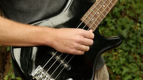 el hombre deja de tocar el bajo eléctrico, afuera