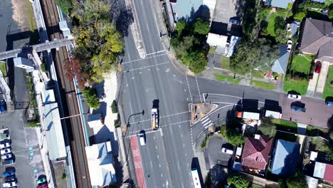 Vista-Panorámica-De-Los-Automóviles-Que-Circulan-Cerca-De-Las-Luces-De-La-Carretera-Principal-En-La-Autopista-Barrio-Suburbios-Calle-Estación-De-Tren-Ourimbah-Australia-Drone-Transporte-Aéreo-Viajes