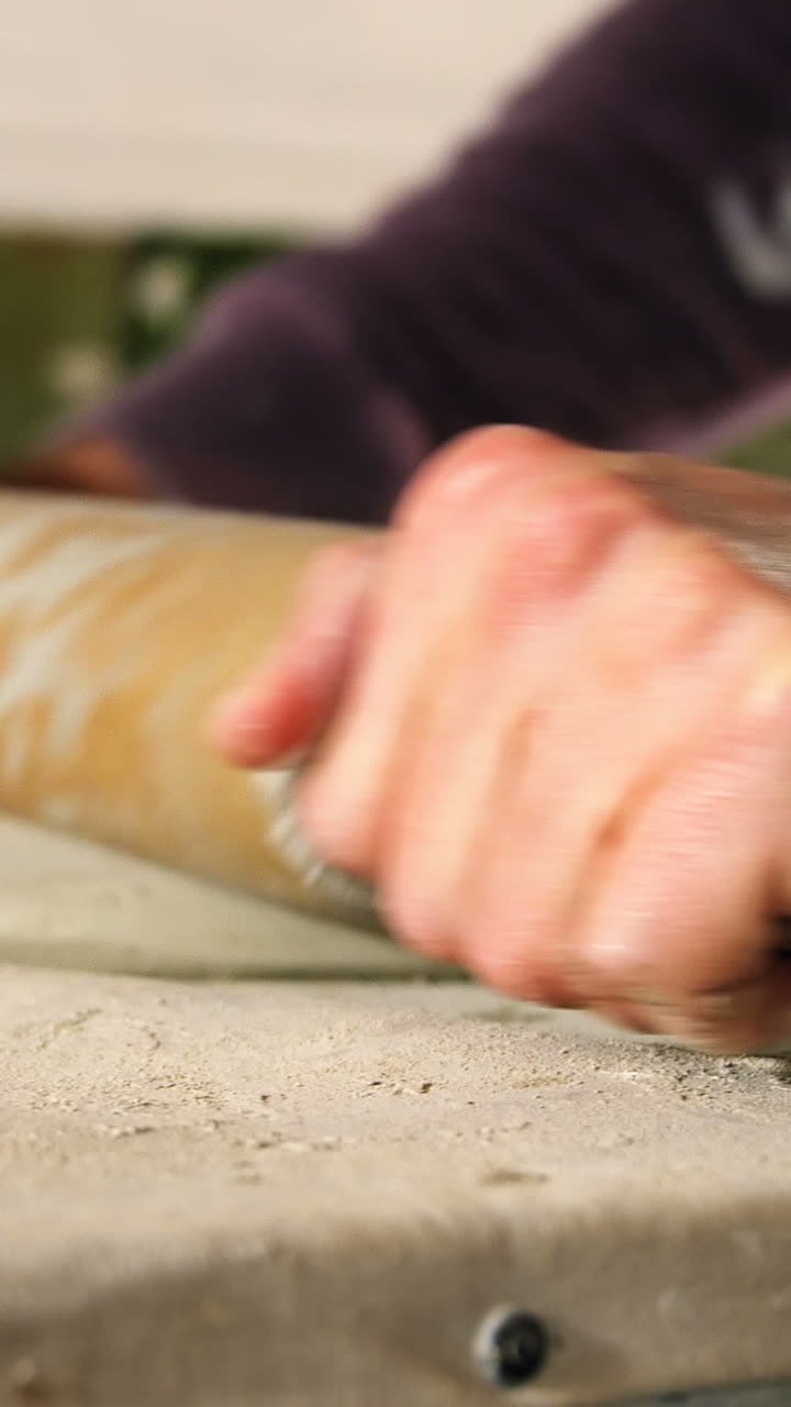 Male potter molding clay with rolling pin