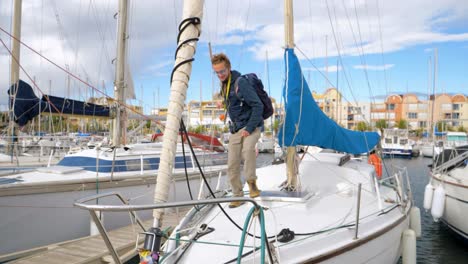 tracking shot of a man getting on his boat and preparing for departure