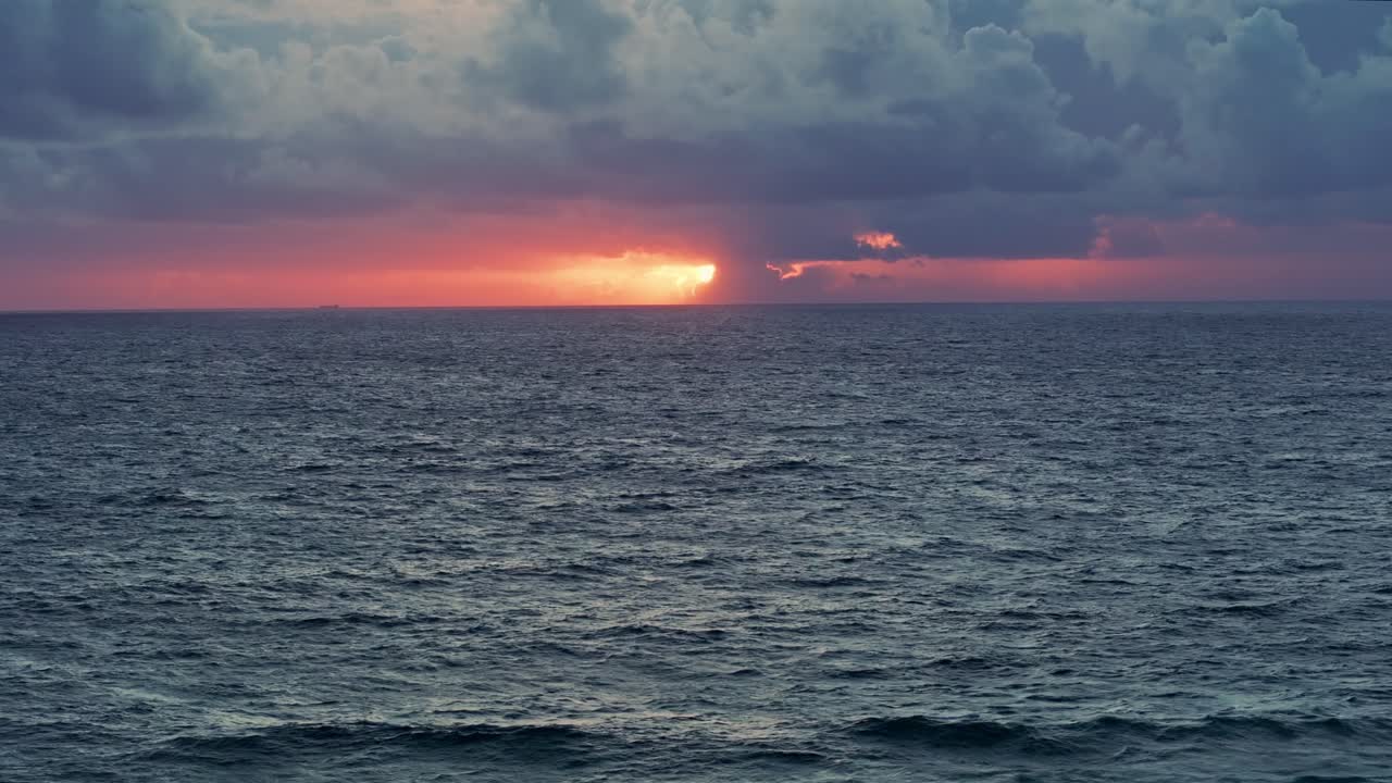 바다 위에서 극적인 해가 지는 모습