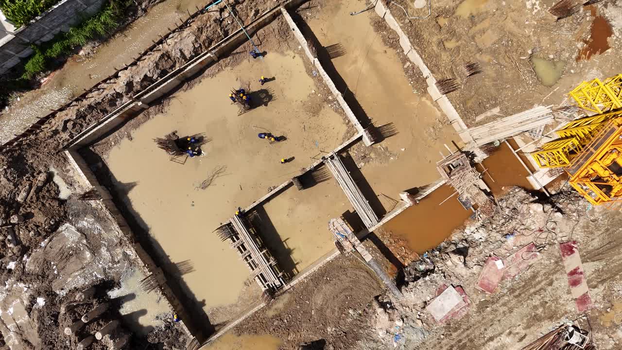 Aerial View of a Construction Site with Workers and Excavated Foundations